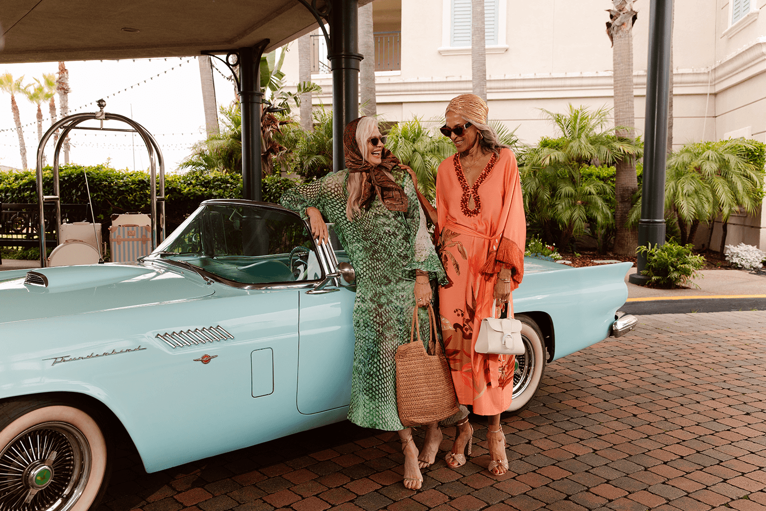 2 ladies standing in front of a car