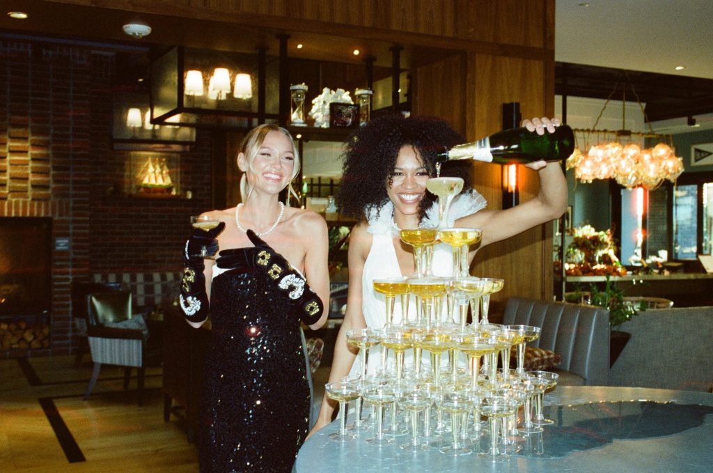 2 women pouring champagne to glasses