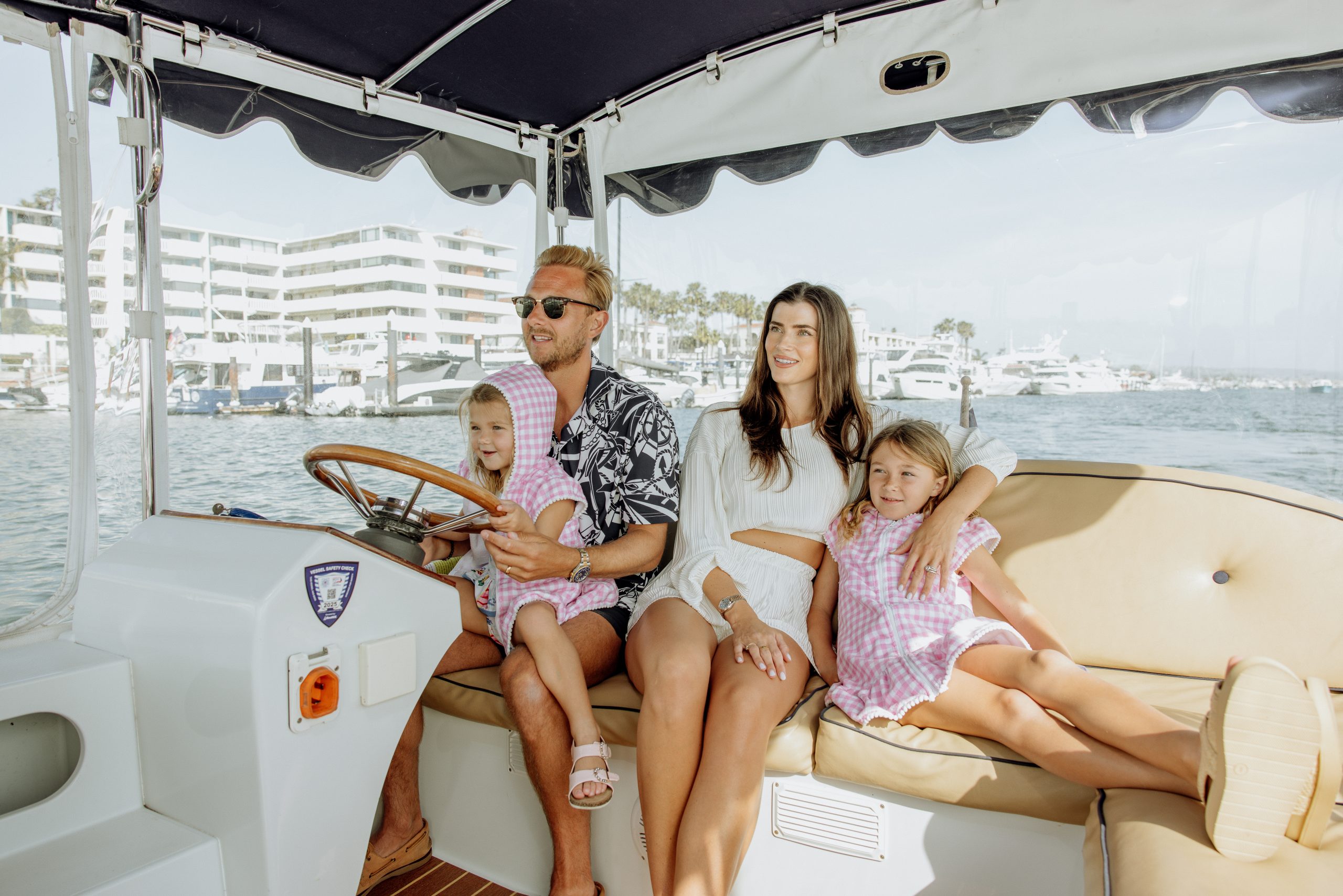dad, mom, and 2 daughters on a duffy boat