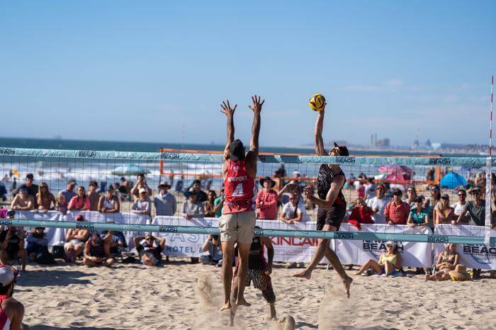 people playing volleyball on the beach