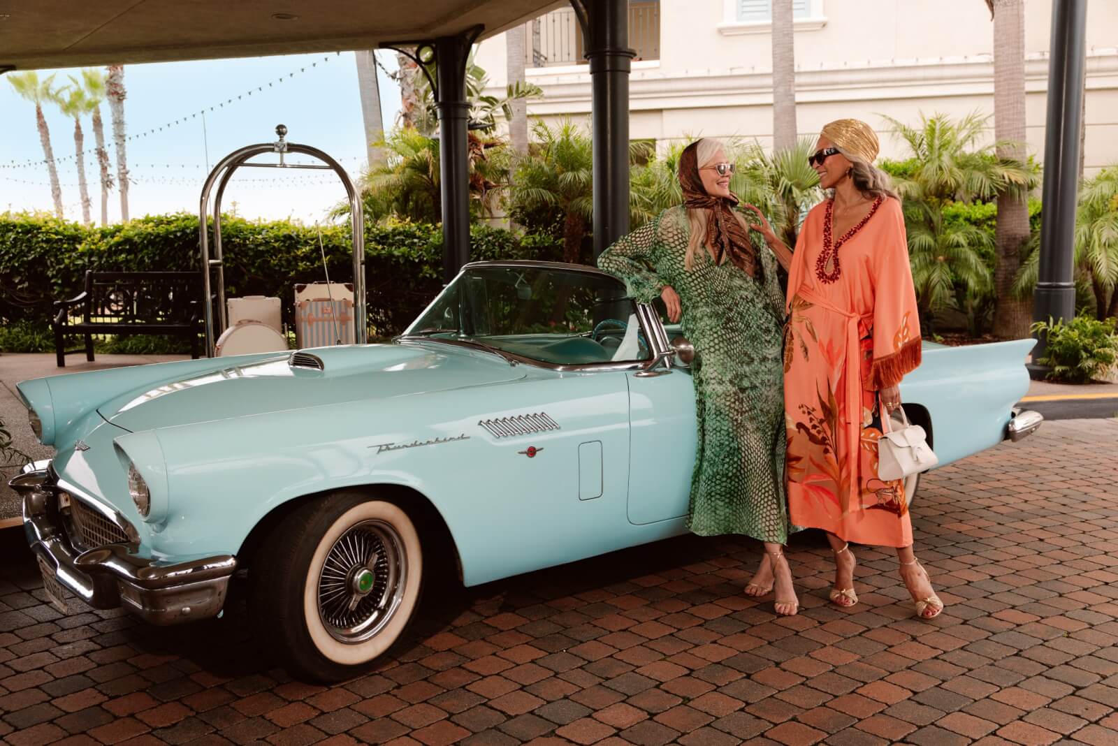 2 women standing in front of a car