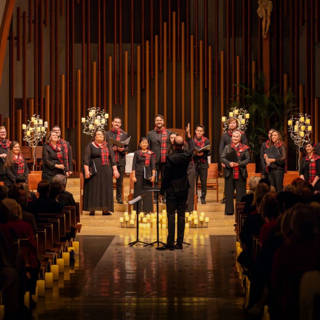Pacific Chorale singing a holiday song at the front of a church.