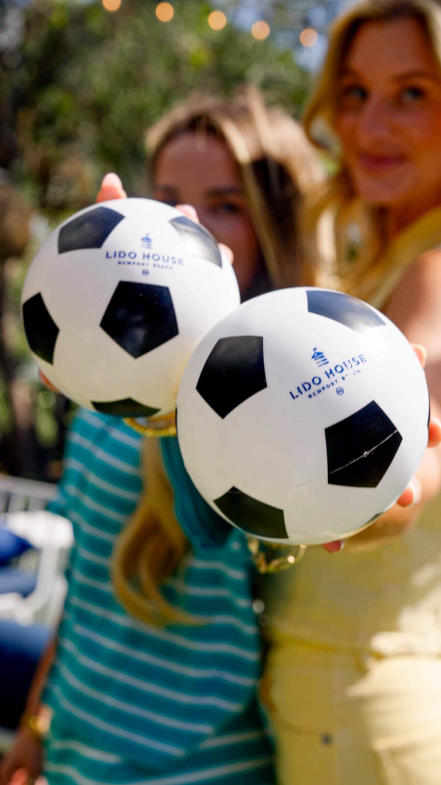 people holding soccer balls