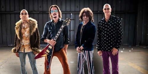 Band posing for picture with guitars