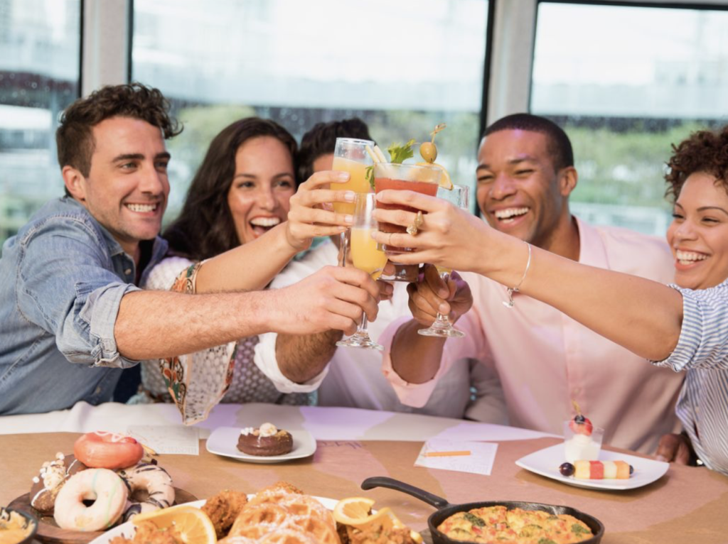 People sitting on a boat doing a cheers with drinks