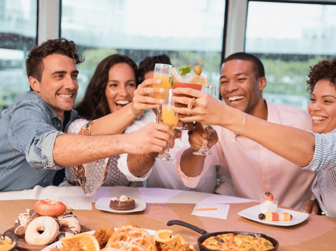 People sitting on a boat doing a cheers with drinks
